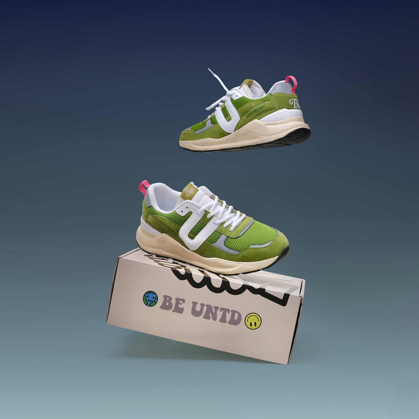 Two UNTD Harmony Runner "Matcha" sneakers, green and white with suede and mesh details, on a blue background