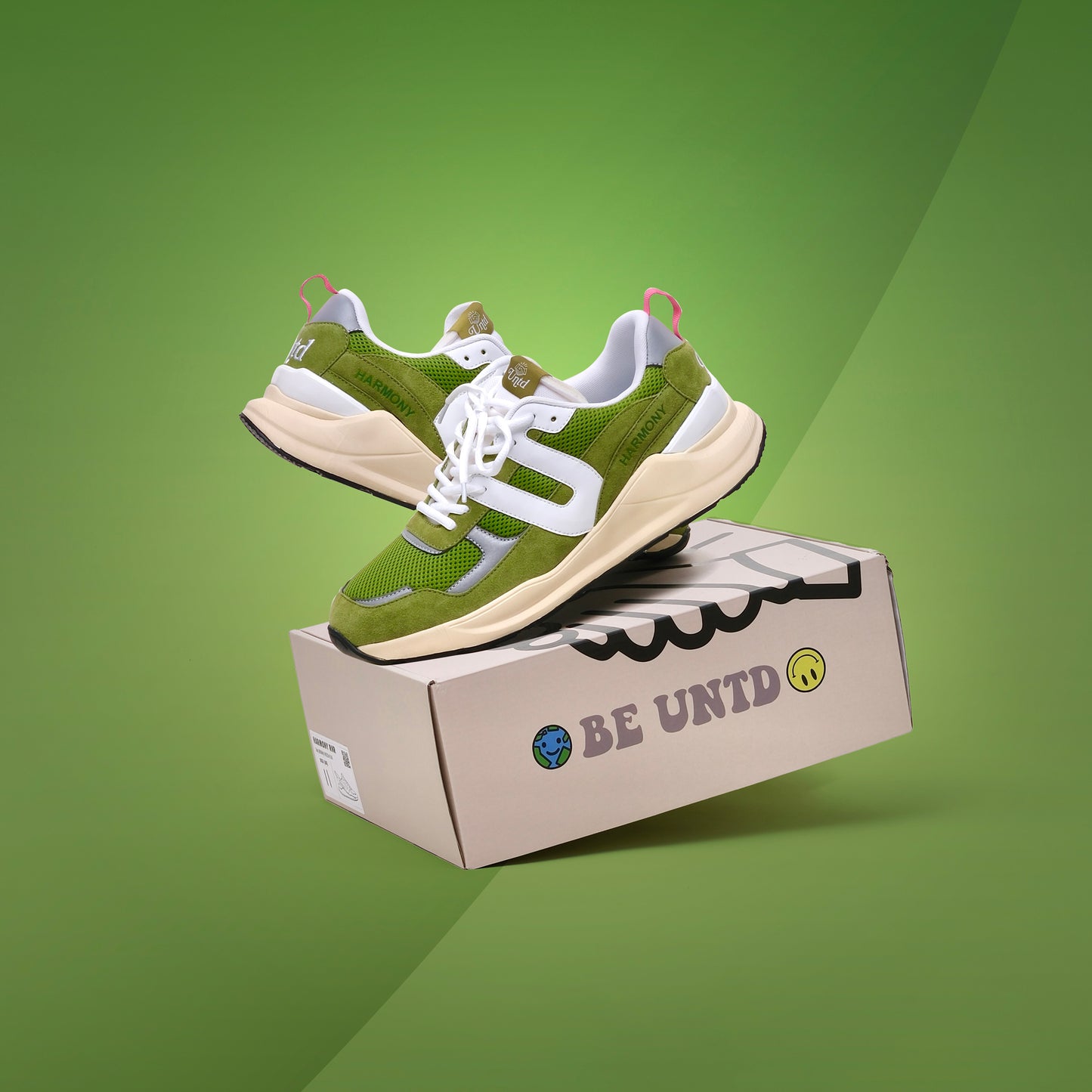 Two UNTD Harmony Runner "Matcha" sneakers, green and white with suede and mesh details, on a green background