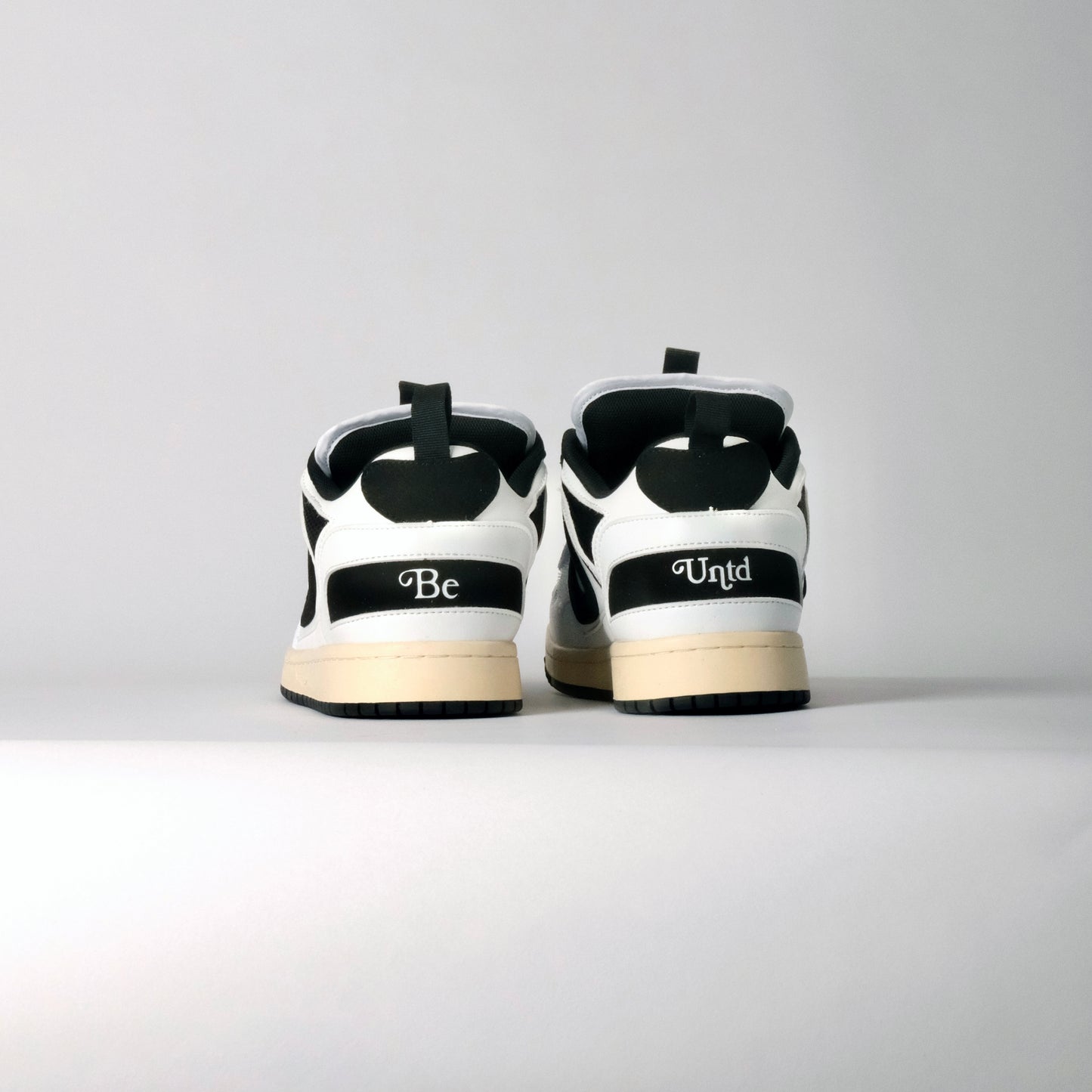 UNTD Amity Low Panda shoe with black toe box, white side panels, and thick black laces