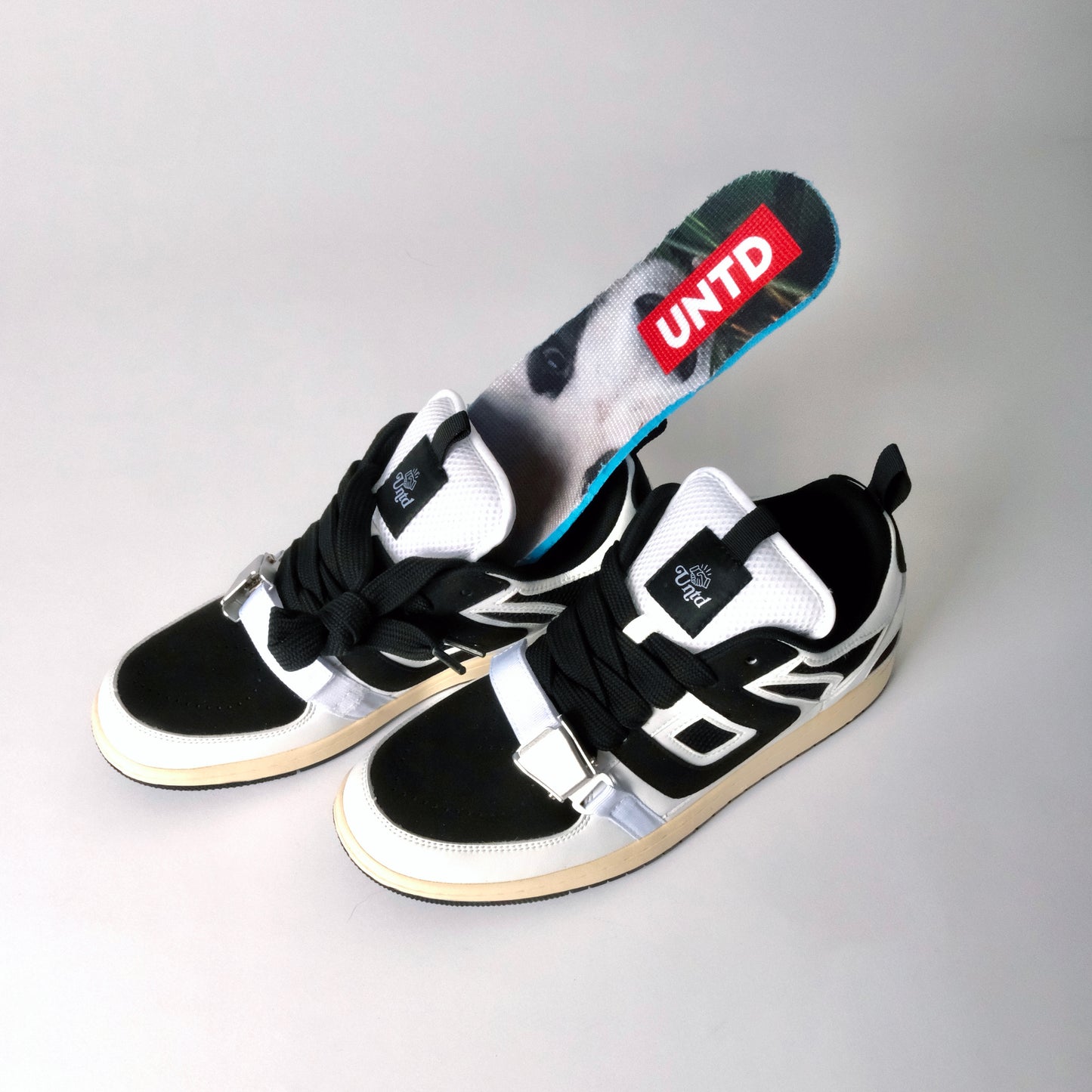 UNTD Amity Low Panda shoe with black toe box, white side panels, and thick black laces